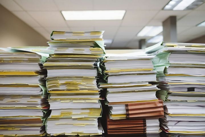 Dokumenty na podložke vedľa notebooku